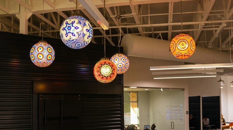 Colorful mosaic globe pendant lights hang from the ceiling in a modern restaurant interior.